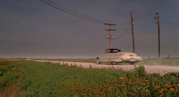 Movie still from “Rain Man” (1988), directed by Barry Levinson – A car driving down a road next to a telephone pole; Extreme Wide shot, High angle