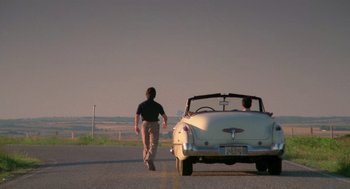 Movie still from “Rain Man” (1988), directed by Barry Levinson – A man walking down the road next to an old car; Wide shot, Low angle