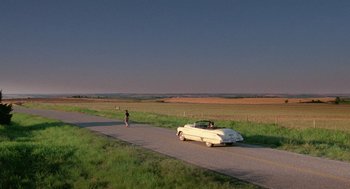 Movie still from “Rain Man” (1988), directed by Barry Levinson – A man is standing on the side of the road next to a car; Extreme Wide shot, High angle