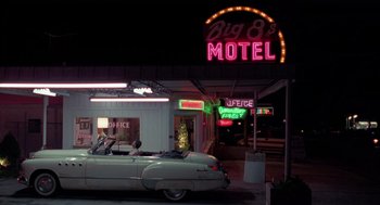 Movie still from “Rain Man” (1988), directed by Barry Levinson – A car parked in front of a motel with neon lights; Extreme Wide shot, Low angle