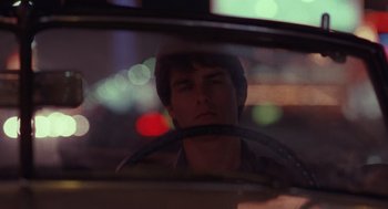 Movie still from “Rain Man” (1988), directed by Barry Levinson – A young man driving a car in the dark; Close Up shot, Over the shoulder angle