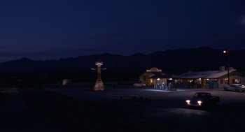 Movie still from “Rain Man” (1988), directed by Barry Levinson – A night scene of a gas station with a gas pump in the middle of the road; Extreme Wide shot, Low angle