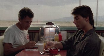 Movie still from “Rain Man” (1988), directed by Barry Levinson – Two men are sitting at a table with a bowl of orange juice; Medium shot, Over the shoulder angle