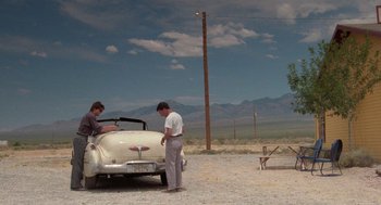 Movie still from “Rain Man” (1988), directed by Barry Levinson – Two men standing next to an antique car; Wide shot, Over the shoulder angle