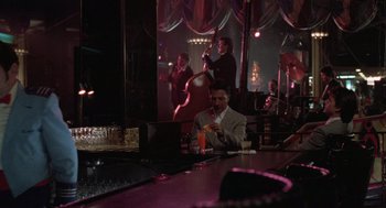 Movie still from “Rain Man” (1988), directed by Barry Levinson – A man sitting at a bar with a drink in his hand; Wide shot, Over the shoulder angle