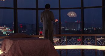 Movie still from “Rain Man” (1988), directed by Barry Levinson – A man standing in front of a window at night; Wide shot, Over the shoulder angle