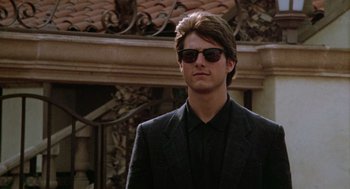 Movie still from “Rain Man” (1988), directed by Barry Levinson – A man in a suit and sunglasses stands in front of a building; Close Up shot, Low angle