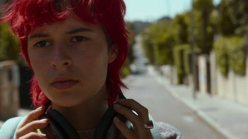 Movie still from “Rainbow” (2022), directed by Paco León – A woman with red hair is standing on the side of the street; Close Up shot, Low angle