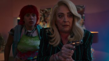 Movie still from “Rainbow” (2022), directed by Paco León – A woman holding a remote control in her hand; Medium shot, Over the shoulder angle