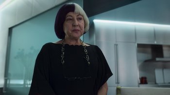 Movie still from “Rainbow” (2022), directed by Paco León – An older woman wearing a black dress and a purple wig; Close Up shot, Over the shoulder angle