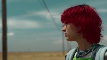 Movie still from “Rainbow” (2022), directed by Paco León – A woman with red hair is standing in a field; Close Up shot, Over the shoulder angle