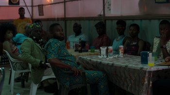 Movie still from “Rainbow” (2022), directed by Paco León – A group of people sitting around a table; Medium shot, High angle