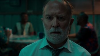 Movie still from “Rainbow” (2022), directed by Paco León – An older man with a beard and a tie; Close Up shot, Over the shoulder angle