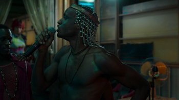 Movie still from “Rainbow” (2022), directed by Paco León – A man with a microphone in his mouth; Close Up shot, Low angle