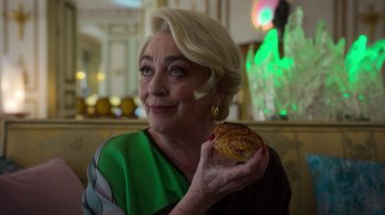 Movie still from “Rainbow” (2022), directed by Paco León – An older woman holding a pastry in her hand; Close Up shot, Over the shoulder angle