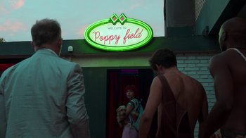 Movie still from “Rainbow” (2022), directed by Paco León – A group of people standing in front of a neon sign; Wide shot, Low angle