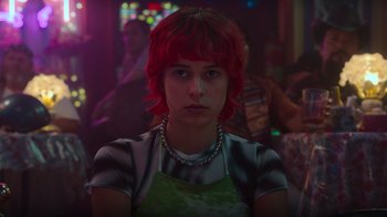 Movie still from “Rainbow” (2022), directed by Paco León – A woman with red hair and a green apron; Close Up shot, Over the shoulder angle