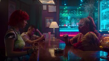 Movie still from “Rainbow” (2022), directed by Paco León – A group of people sitting at a table in a bar; Medium shot, Over the shoulder angle