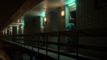 Movie still from “Rainbow” (2022), directed by Paco León – A person standing in a room next to a brick wall; Extreme Wide shot, Low angle