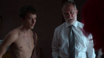 Movie still from “Rainbow” (2022), directed by Paco León – A man standing next to another man wearing a tie; Medium shot, Over the shoulder angle