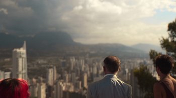 Movie still from “Rainbow” (2022), directed by Paco León – A man in a suit looking out over a city; Extreme Wide shot, Low angle