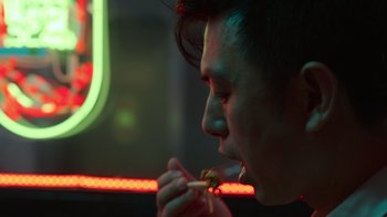 Movie still from “Rainbow” (2022), directed by Paco León – A man is eating a hot dog in a restaurant; Close Up shot, Over the shoulder angle