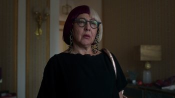 Movie still from “Rainbow” (2022), directed by Paco León – An older woman wearing a black top and a purple wig; Close Up shot, Over the shoulder angle