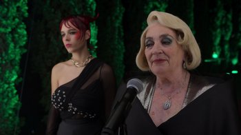 Movie still from “Rainbow” (2022), directed by Paco León – Two women are standing next to each other in front of a microphone; Close Up shot, Over the shoulder angle