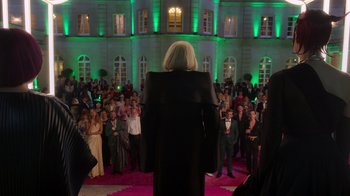 Movie still from “Rainbow” (2022), directed by Paco León – A crowd of people standing in front of a large building; Extreme Wide shot, Over the shoulder angle