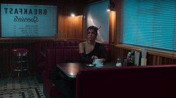 Movie still from “Rainbow” (2022), directed by Paco León – A woman sitting at a table in a restaurant; Medium shot, Low angle