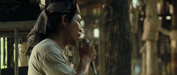 Movie still from “Rambo” (2008), directed by Sylvester Stallone – A man holding a microphone in his hand; Close Up shot, Low angle