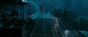 Movie still from “Rambo” (2008), directed by Sylvester Stallone – A person walking on a bridge in the rain; Wide shot, High angle