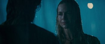 Movie still from “Rambo” (2008), directed by Sylvester Stallone – A woman is standing in the rain with her eyes closed; Close Up shot, Over the shoulder angle