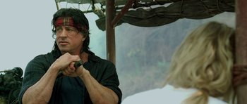 Movie still from “Rambo” (2008), directed by Sylvester Stallone – A man holding a microphone in his mouth; Close Up shot, Over the shoulder angle