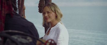 Movie still from “Rambo” (2008), directed by Sylvester Stallone – A beautiful blond woman standing next to a boat; Close Up shot, Over the shoulder angle