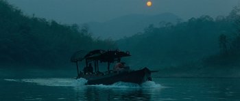 Movie still from “Rambo” (2008), directed by Sylvester Stallone – A boat with people on it traveling on a river; Extreme Wide shot, Low angle