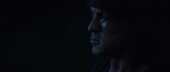 Movie still from “Rambo” (2008), directed by Sylvester Stallone – A person's face in the dark; Close Up shot, Low angle