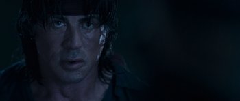 Movie still from “Rambo” (2008), directed by Sylvester Stallone – A man's face in the dark; Close Up shot, Over the shoulder angle