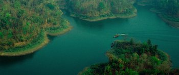 Movie still from “Rambo” (2008), directed by Sylvester Stallone – A boat traveling down a river surrounded by green hills; Extreme Wide shot, High angle