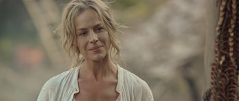 Movie still from “Rambo” (2008), directed by Sylvester Stallone – A woman with blonde hair is smiling for the camera; Close Up shot, Over the shoulder angle