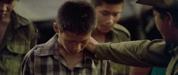 Movie still from “Rambo” (2008), directed by Sylvester Stallone – A man with his hand on his neck and another man with his hand on his head; Close Up shot, Over the shoulder angle