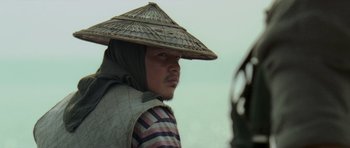 Movie still from “Rambo” (2008), directed by Sylvester Stallone – A man wearing a straw hat is looking at the camera; Close Up shot, Over the shoulder angle