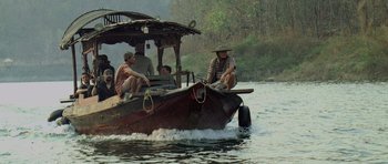 Movie still from “Rambo” (2008), directed by Sylvester Stallone – A group of people riding on a boat on a river; Wide shot, High angle