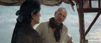 Movie still from “Rambo” (2008), directed by Sylvester Stallone – A man and a woman talking under an awning; Close Up shot, Over the shoulder angle