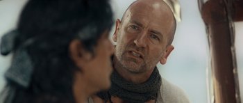 Movie still from “Rambo” (2008), directed by Sylvester Stallone – A man with a scarf on his neck looking into a mirror; Close Up shot, Over the shoulder angle