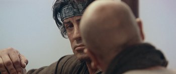 Movie still from “Rambo” (2008), directed by Sylvester Stallone – A person with a head band on; Close Up shot, Over the shoulder angle