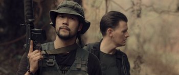 Movie still from “Rambo” (2008), directed by Sylvester Stallone – A man in a hat and a man in a jacket; Close Up shot, Over the shoulder angle