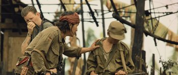 Movie still from “Rambo” (2008), directed by Sylvester Stallone – A man in a hat is touching another man in a hat; Medium shot, Over the shoulder angle