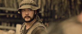 Movie still from “Rambo” (2008), directed by Sylvester Stallone – A person wearing a hat; Close Up shot, Over the shoulder angle