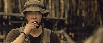 Movie still from “Rambo” (2008), directed by Sylvester Stallone – A man wearing a hat and holding a knife in his mouth; Close Up shot, Low angle